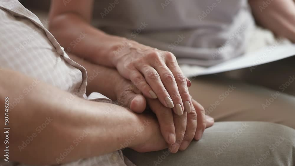 Close up middle aged woman stroking hand of older pensioner. Close up middle aged woman stroking hand of older pensioner.