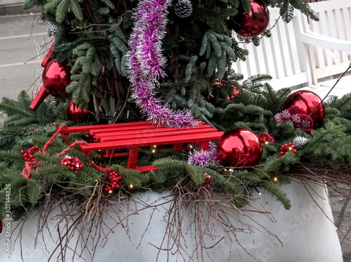 Christmas. Red sleds adorn the festive installation with a Christmas tree and balls.