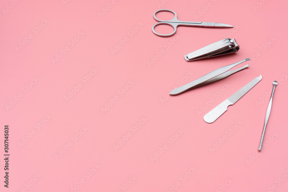 Set of manicure instruments and tools on pink background, top view, copy space Set of manicure instruments and tools on pink background, top view, copy space