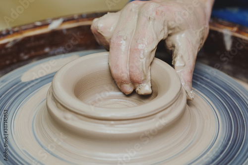 Woman hands on pottery wheel. Craftsman artist shapes pot