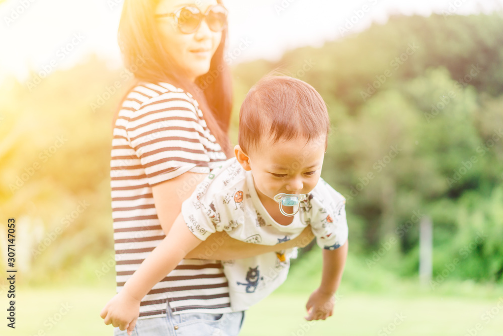 Fototapeta premium Happy loving family.Asian mother and toddler boy child playing fly and have fun in the park at home.