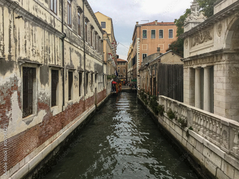 Venice secondary canal lined with aging buildings
