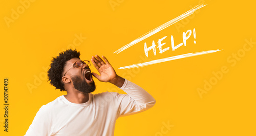 Worried afro guy shouting help over orange background photo