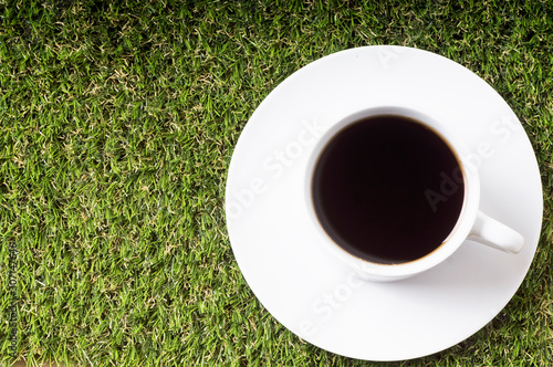 Black coffee cup top view on grass background