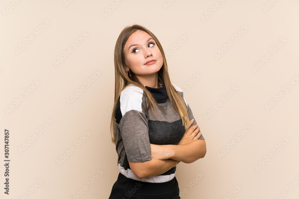 Teenager girl over isolated background making doubts gesture while lifting the shoulders Teenager girl over isolated background making doubts gesture while lifting the shoulders