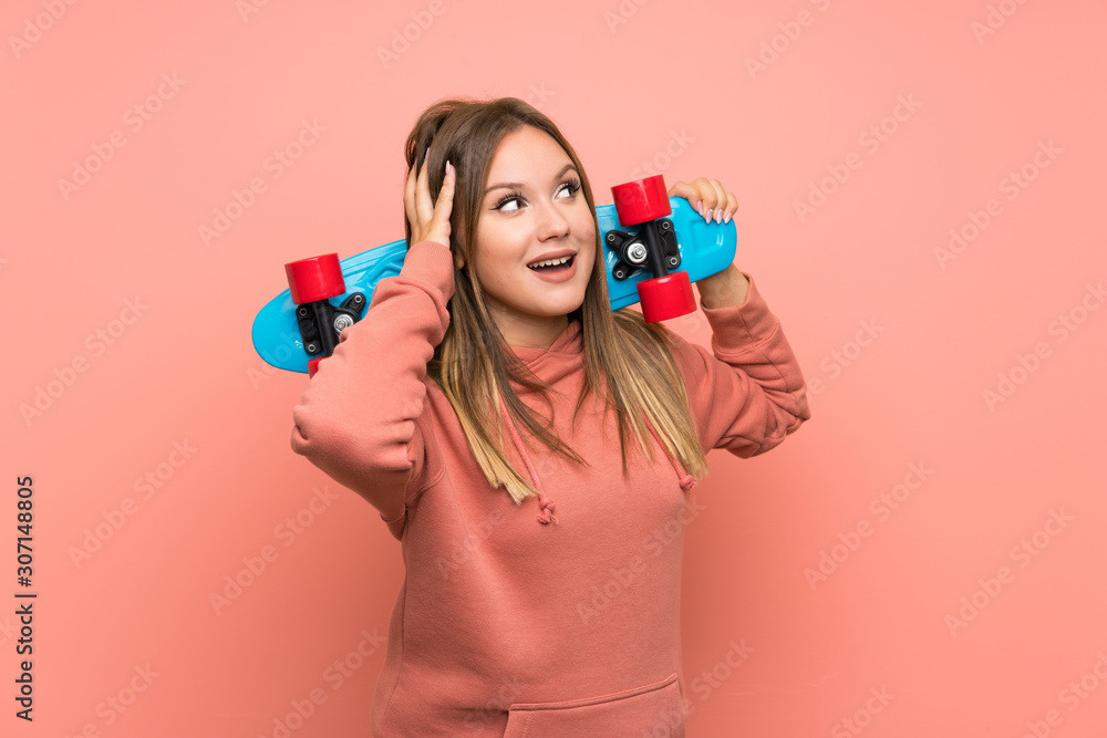 Teenager girl with skate over isolated pink background Teenager girl with skate over isolated pink background