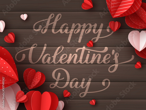 Happy Valentines day greeting card. Decorative paper cut hearts with handwritten text on brown wooden background. Vector illustration.
