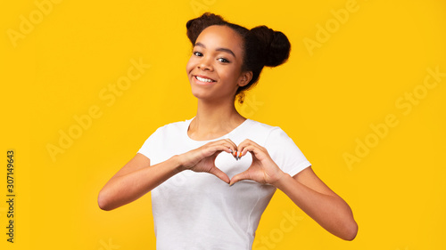 Fotografia, Obraz Smiling african american teen showing heart gesture