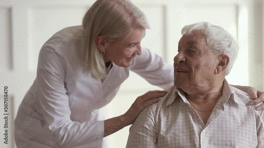 Friendly middle aged nurse embracing shoulders of 80s male pensioner. Friendly middle aged nurse embracing shoulders of 80s male pensioner.
