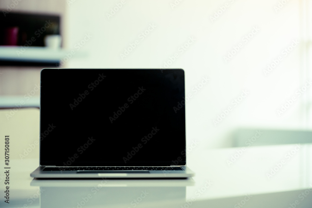 Fototapeta premium Close up of on laptop computer, tablet pc, notebook on office table.education, business and technology concept.Vintage tone.copy space on black display.
