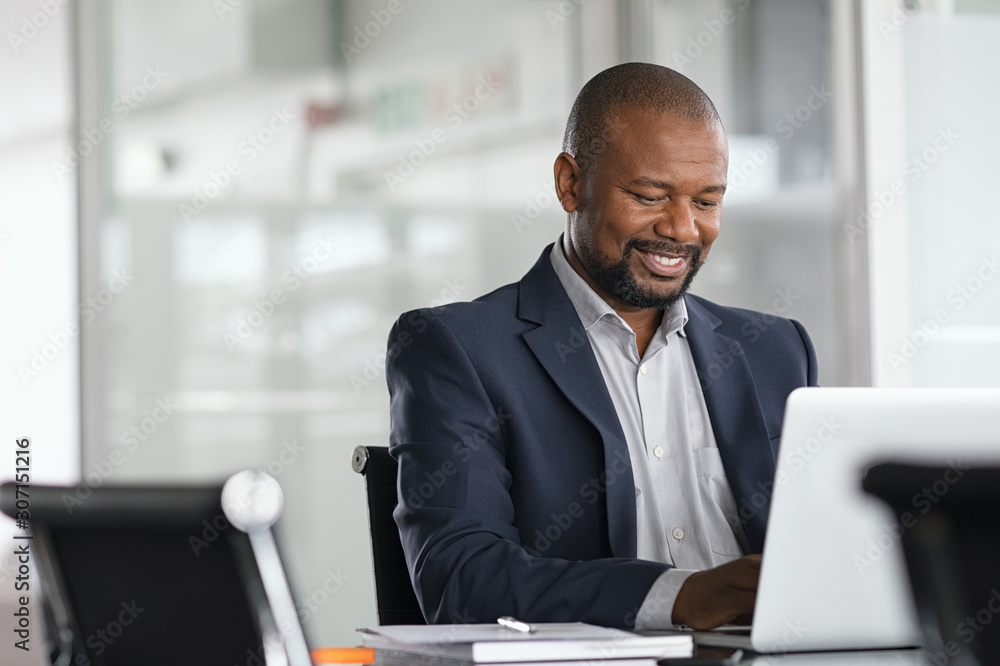 Black mature businessman working on laptop Black mature businessman working on laptop