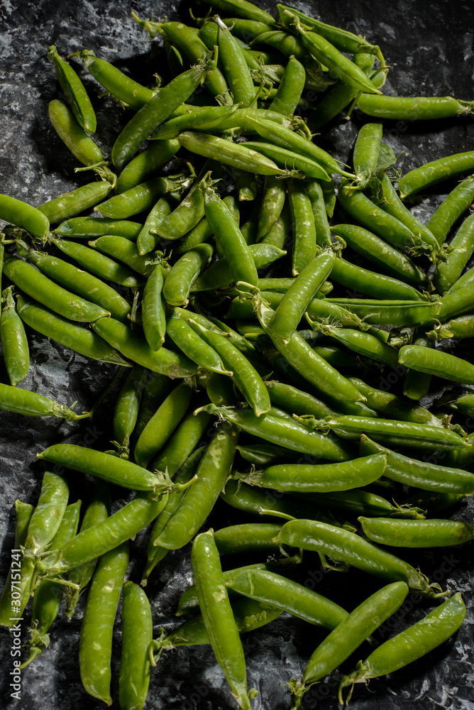 green peas, on asbestos black and white background, in a rustic style green peas, on asbestos black and white background, in a rustic style
