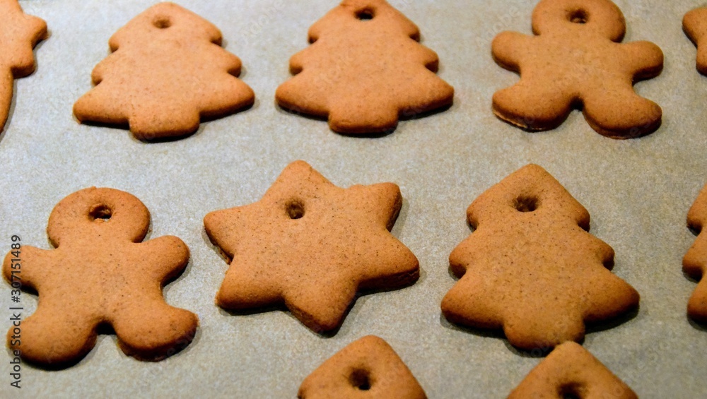 Christmas cookies. Homemade gingerbread cookies in various shapes on the baking tray. Cookies freshly made at home, golden browned colored cookies before decorating with icing Christmas cookies. Homemade gingerbread cookies in various shapes on the baking tray. Cookies freshly made at home, golden browned colored cookies before decorating with icing