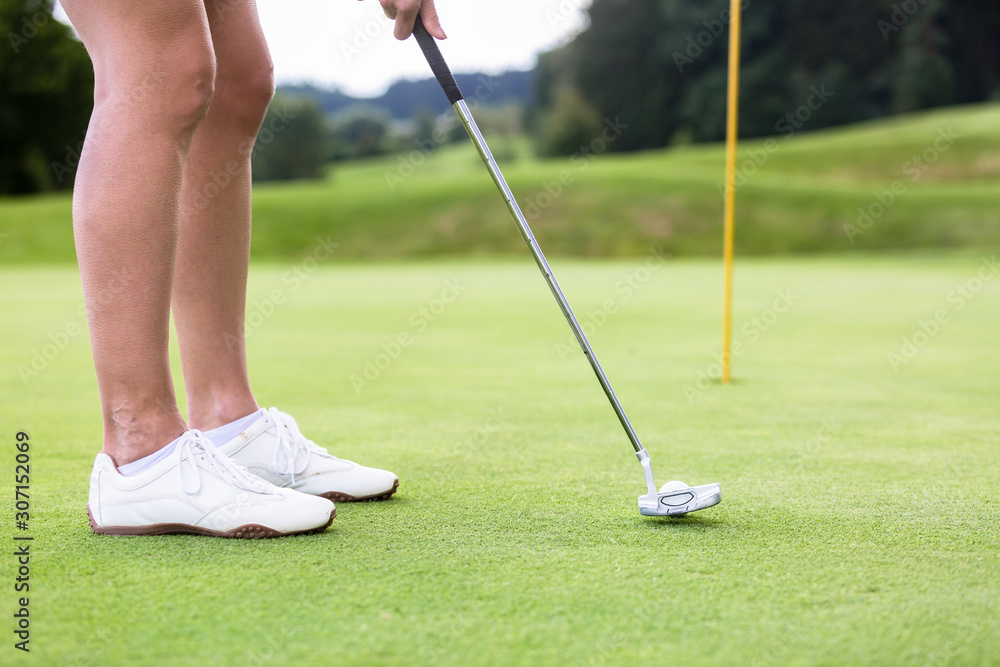 Obraz premium Golfer putting golf ball on the green golf