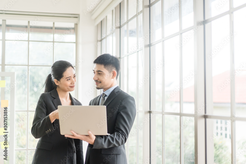 Beautiful asian business man and woman looking in laptop in office and happy.Asian business adviser meeting to analyze and discuss the situation.Investment Consultant,Financial Consultant. Beautiful asian business man and woman looking in laptop in office and happy.Asian business adviser meeting to analyze and discuss the situation.Investment Consultant,Financial Consultant.