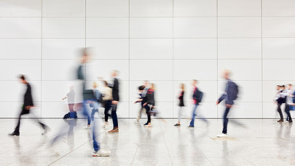 Anonymous business people hurry through trade fair hall