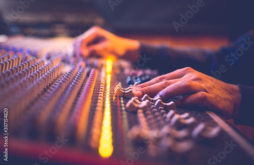 male producer, sound engineer hands working on audio mixing console in broadcasting, recording studio © princeoflove
