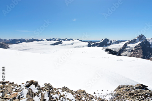 Wide snow-covered glacier landscape with rocky mountains in the background at a bright sunny day. Oetztal Alps, Tyrol, Austria photo
