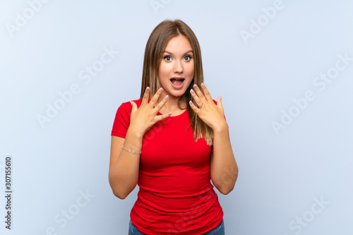 Teenager girl over isolated blue background with surprise facial expression