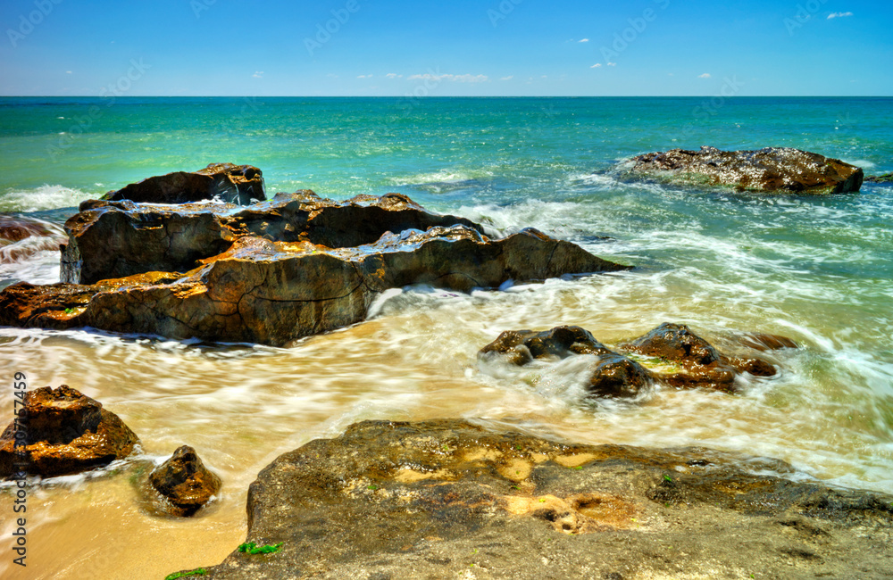 Beautiful landscape with rocks and sea waves on a sunny beach Beautiful landscape with rocks and sea waves on a sunny beach