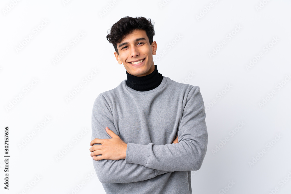 Young Argentinian man over isolated white background keeping the arms crossed in frontal position Young Argentinian man over isolated white background keeping the arms crossed in frontal position