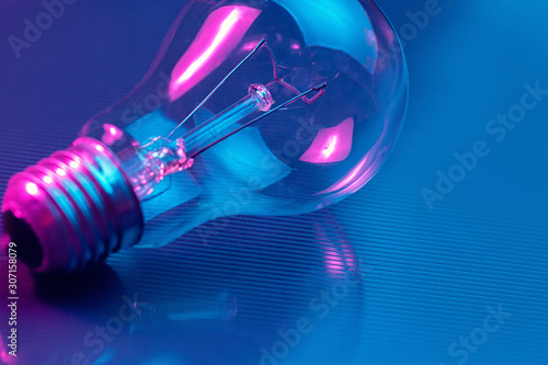 Photo of light bulb lamp in neon light. Ideea concept.