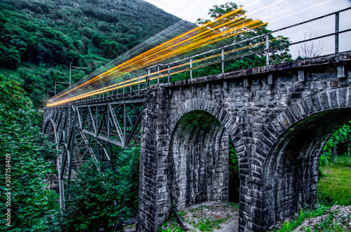 Train Passing the Bridge in Long Exposure in Switzerland. photo