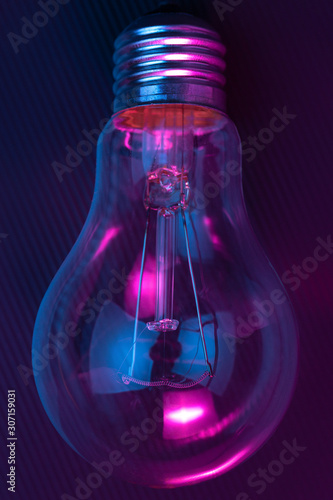 Photo of light bulb lamp in neon light. Ideea concept.