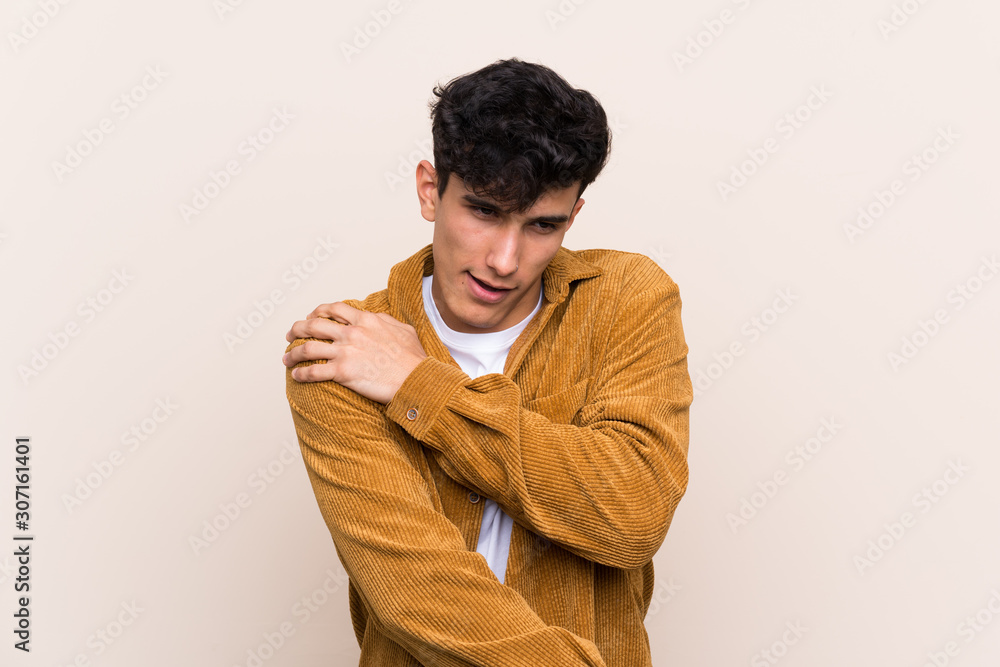 Young Argentinian man over isolated background suffering from pain in shoulder for having made an effort Young Argentinian man over isolated background suffering from pain in shoulder for having made an effort
