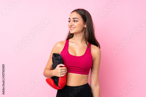 Young sport girl over isolated pink background with boxing gloves © luismolinero
