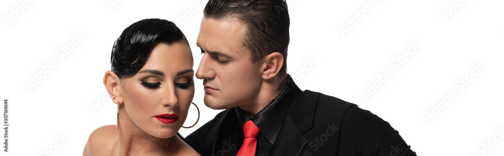 panoramic shot of handsome, confident dancer looking at partner while performing tango isolated on white