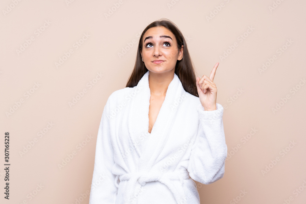 Young girl in a bathrobe over isolated background pointing with the index finger a great idea Young girl in a bathrobe over isolated background pointing with the index finger a great idea