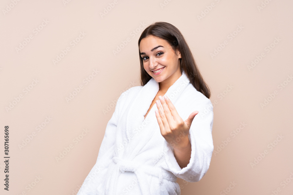 Young girl in a bathrobe over isolated background inviting to come Young girl in a bathrobe over isolated background inviting to come