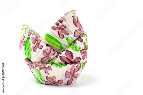 Paper, disposable muffin baking dish with a delicate floral pattern, shot on a white background