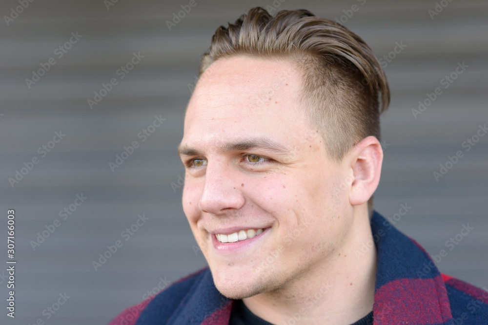 Fototapeta premium Handsome young man looking aside with a smile