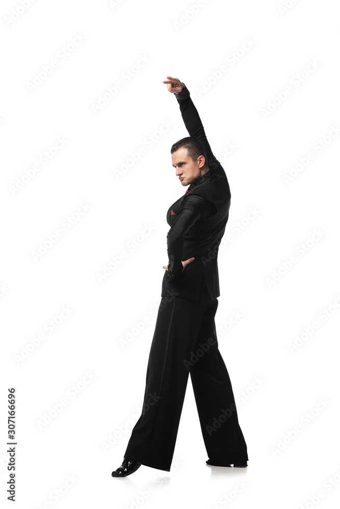 expressive dancer in elegant black suit performing tango with hand on hip on white background