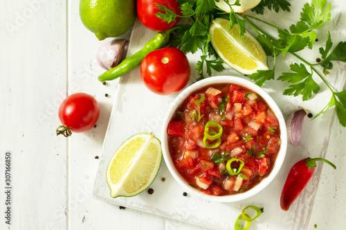 Traditional mexican homemade salsa sauce and ingredients on a white wooden table. Top view on a flat background. Copy space. photo