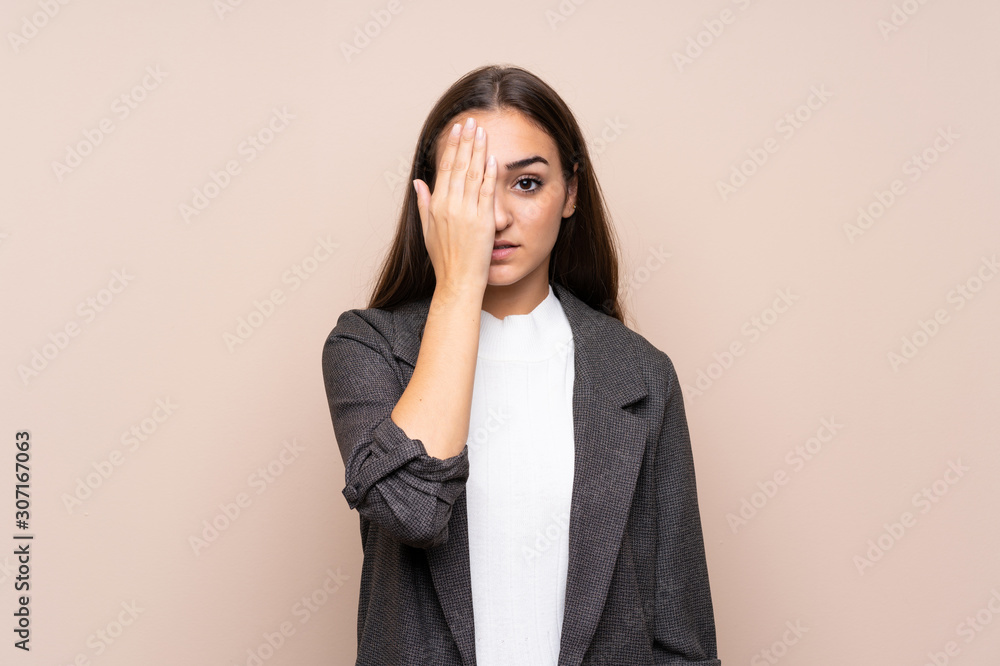 Young girl over isolated background covering a eye by hand Young girl over isolated background covering a eye by hand