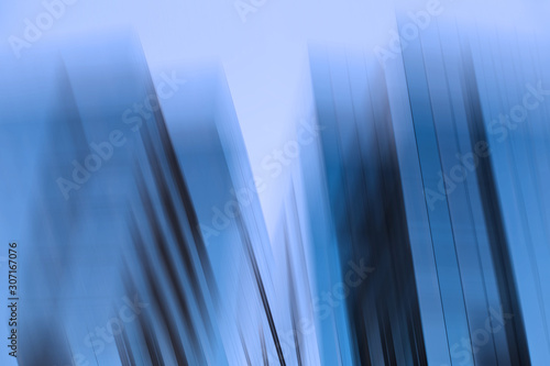 Abstract business modern city urban futuristic architecture background, motion blur, reflection in glass of high rise skyscraper facade, toned blue picture with bokeh. Real estate concept