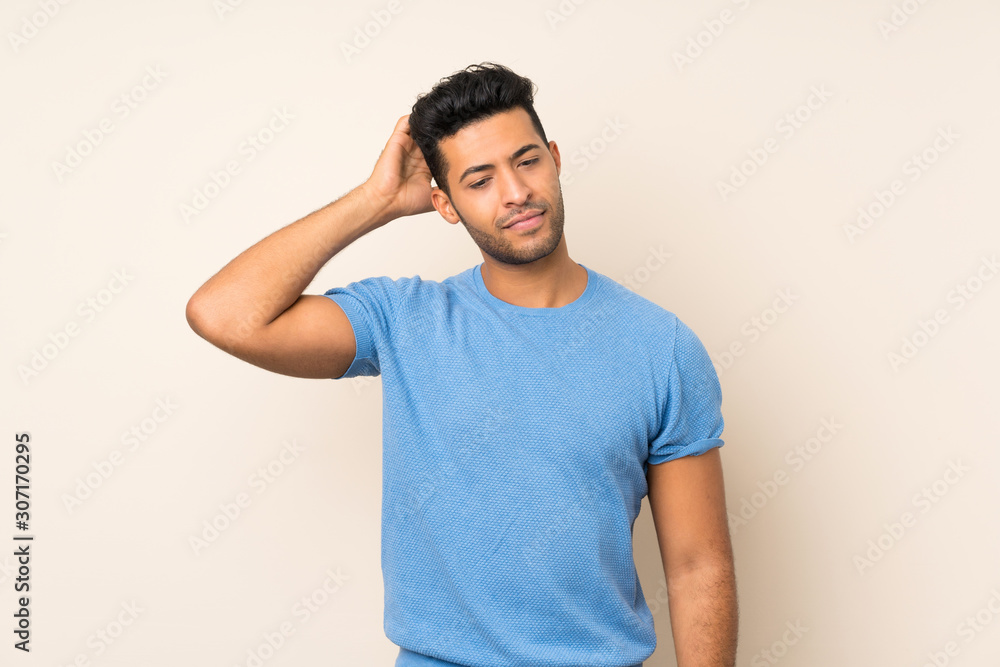 Young handsome man over isolated background having doubts while scratching head Young handsome man over isolated background having doubts while scratching head