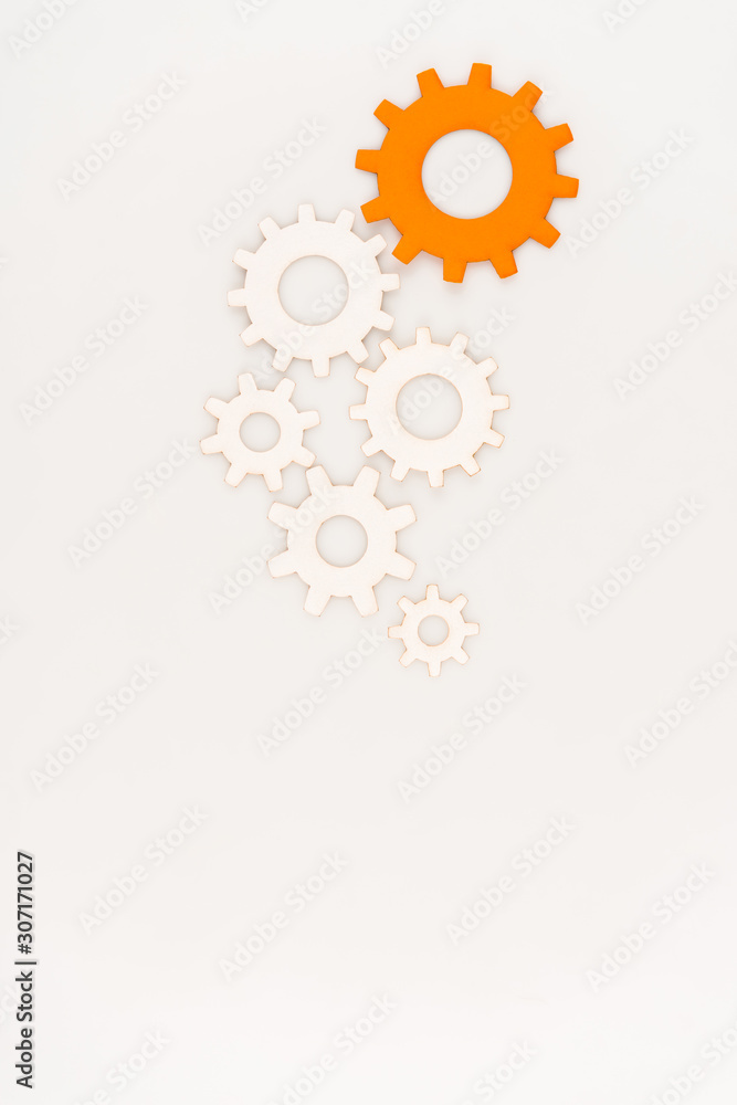top view of one orange gear among another isolated on white top view of one orange gear among another isolated on white