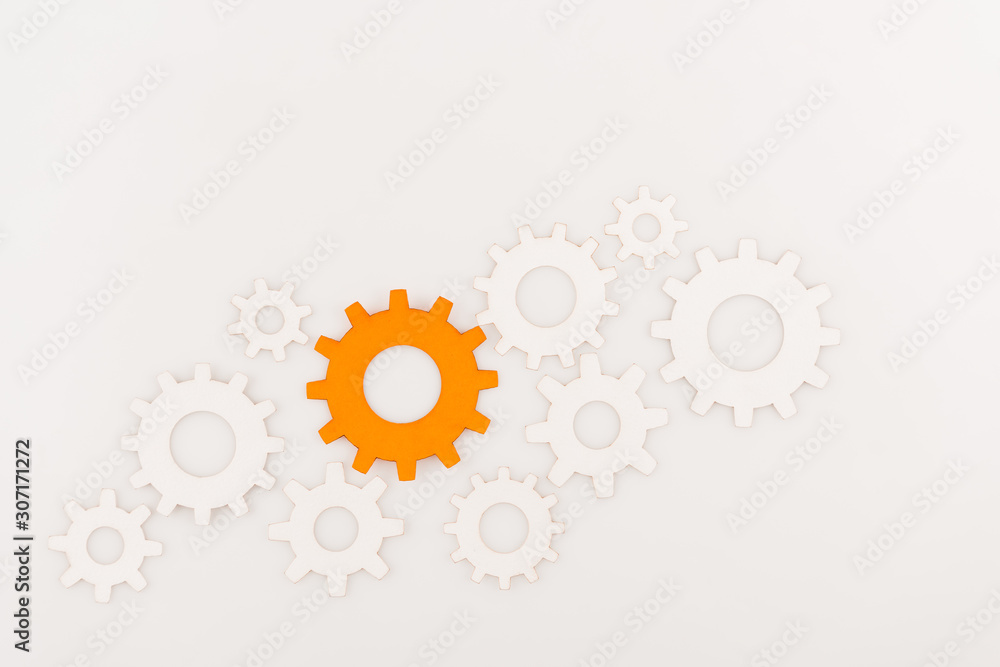 top view of one orange gear among another isolated on white top view of one orange gear among another isolated on white