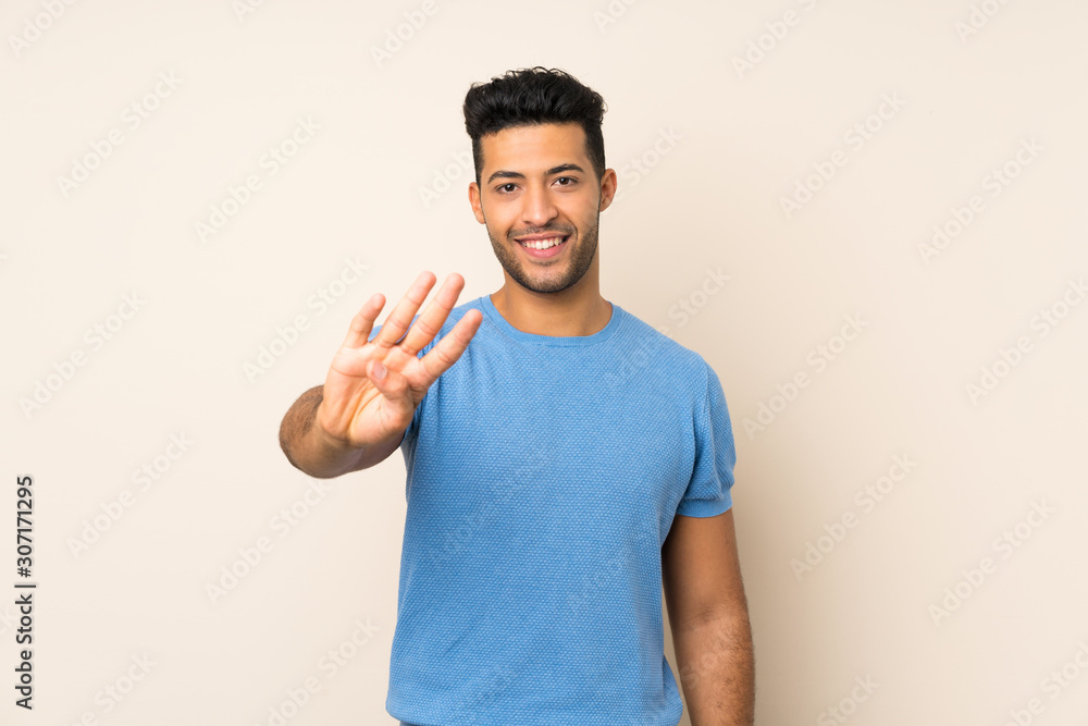 Young handsome man over isolated background happy and counting four with fingers Young handsome man over isolated background happy and counting four with fingers