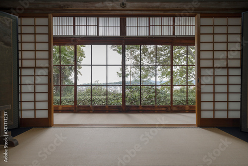 View of green trees and Kyoto from a window in a traditional room with shoji dividers and tatami in Honen-in temple photo