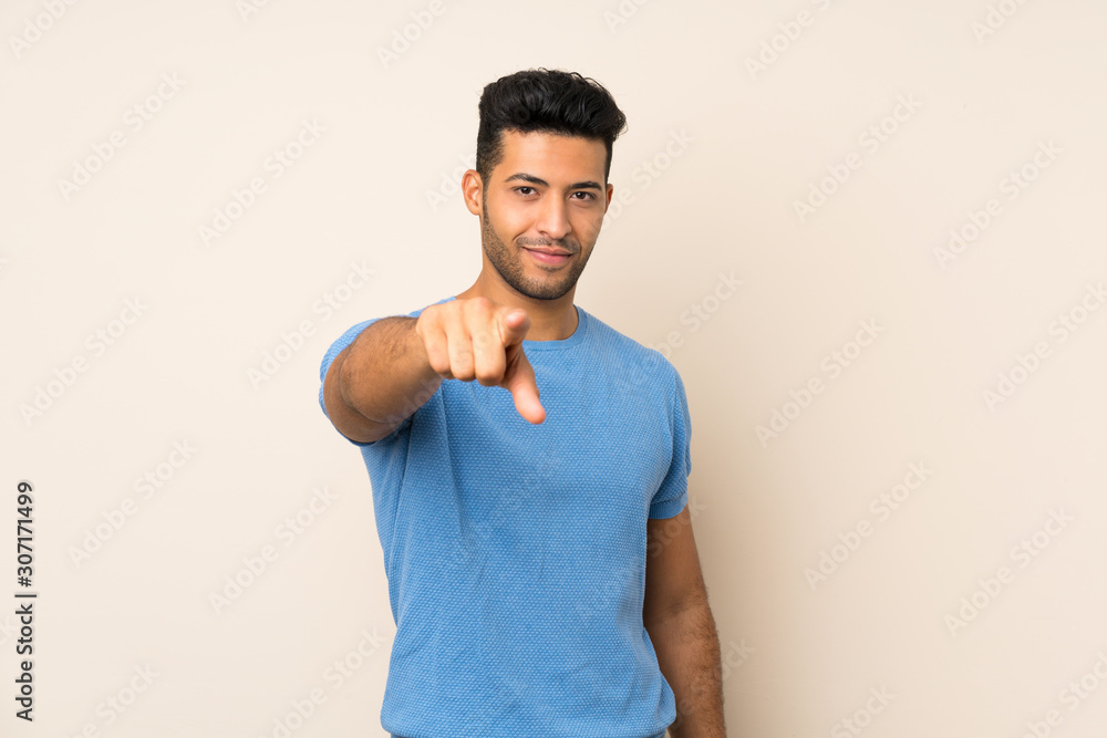 Young handsome man over isolated background points finger at you with a confident expression Young handsome man over isolated background points finger at you with a confident expression