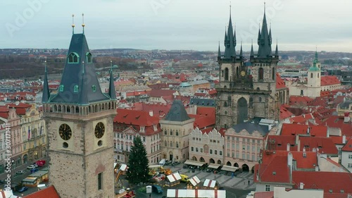 Prague, Czech Republic - 4K drone flying by the tower of the Old Town Hall towards the famous Church of our Lady Before Tyn on a winter morning. Traditional Christmas market bellow at Old Town Square