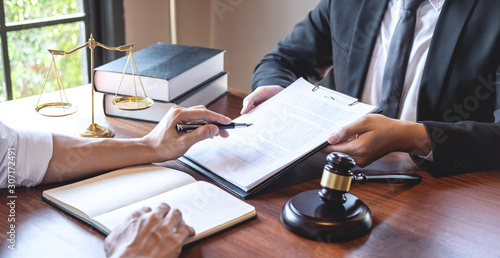 Male lawyer discussing negotiation legal case with client meeting with document contact in courtroom, law and justice concept