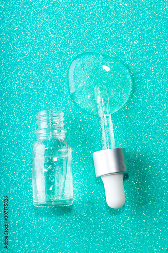 Face serum close-up on the trendy mint background. Collagen, hyaluronic acid for skin care. Achievements of modern science in cosmetic to preserve beauty. Close-up.