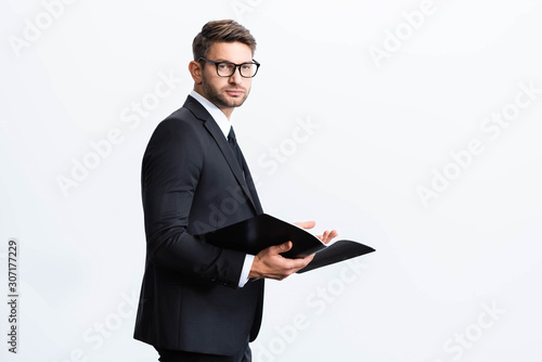 businessman in suit holding folder and looking at camera during conference isolated on white