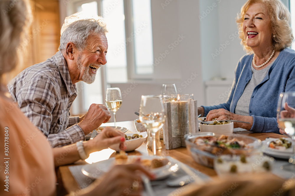Cheerful senior man having fun during a lunch with his friends at home. Cheerful senior man having fun during a lunch with his friends at home.
